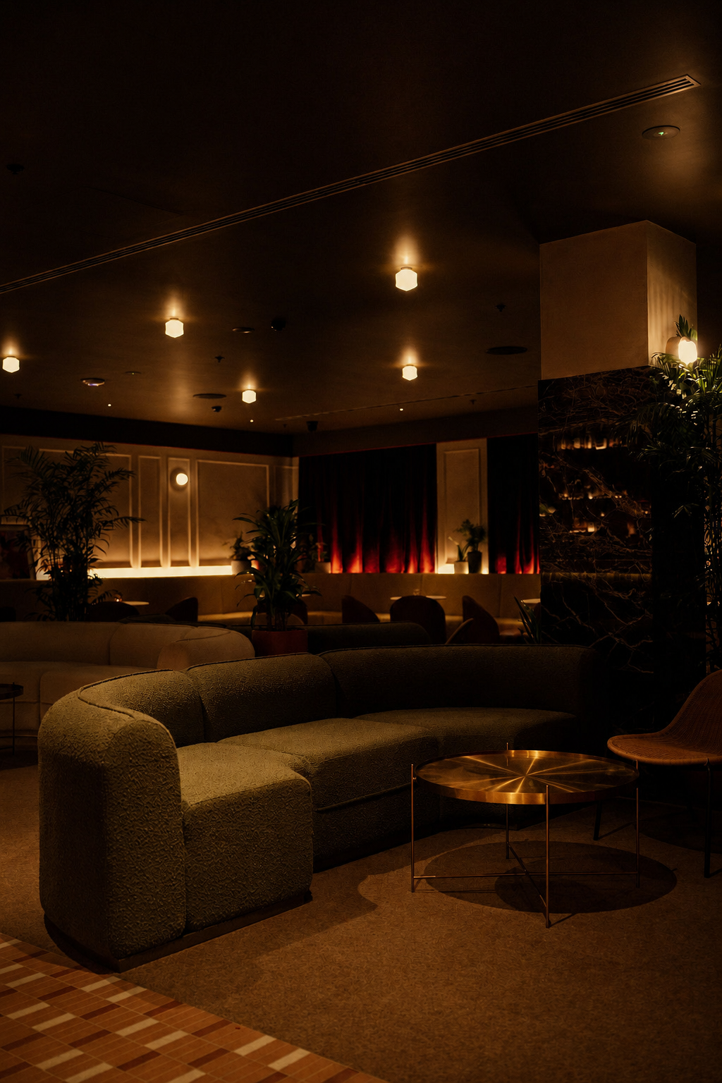 The SOHO lounge interior, lit for an evening, with banquette seating beneath red velvet curtains