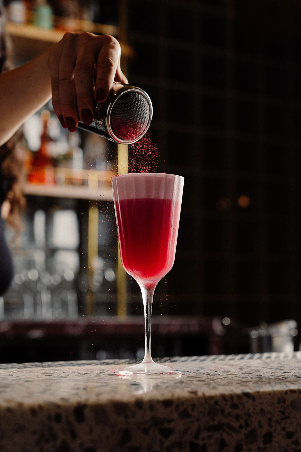 A bright pink sour dusted with red garnish powder in a coupe glass at the SOHO bar