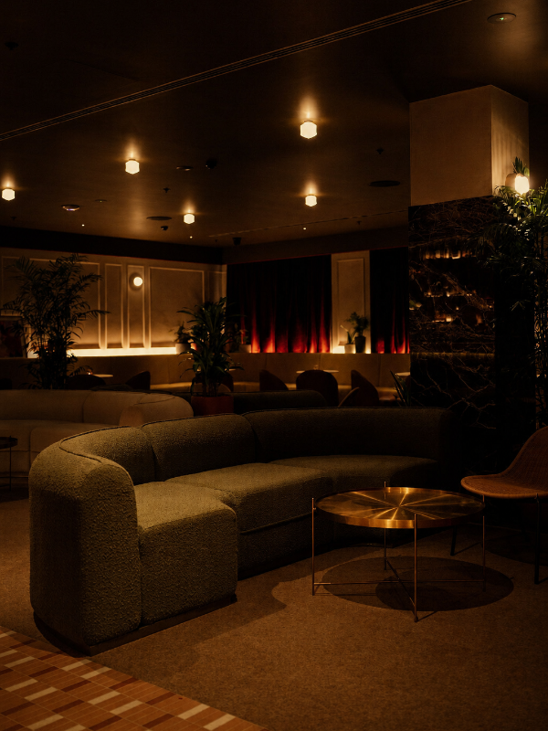 The SOHO lounge under low light with deep seating and warm tones